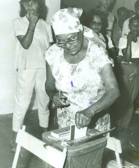 Eleitora votando em uma urna de lona. 